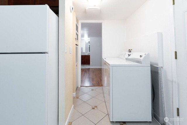 washroom featuring separate washer and dryer and light tile patterned floors