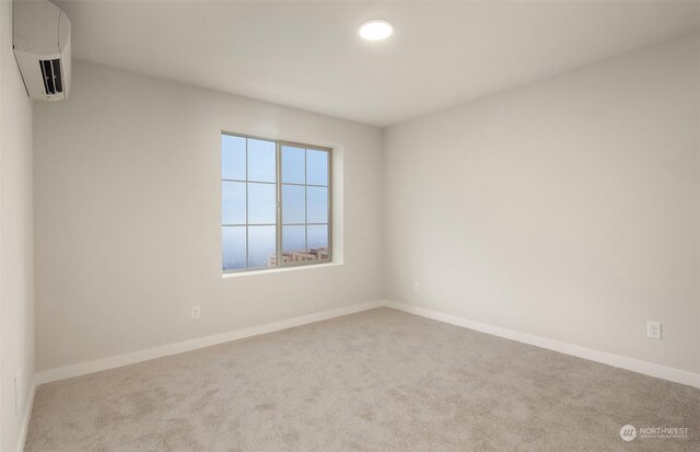 carpeted spare room with a wall mounted air conditioner