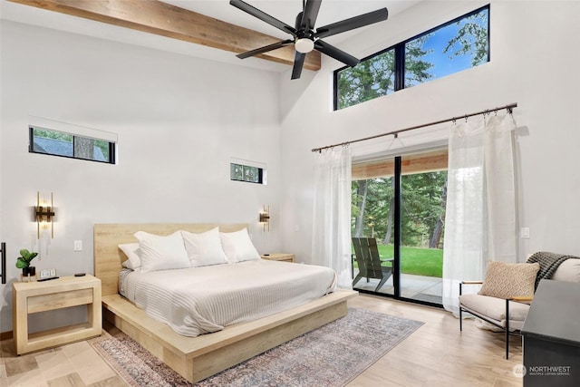 bedroom featuring beam ceiling, access to exterior, ceiling fan, a high ceiling, and light hardwood / wood-style floors