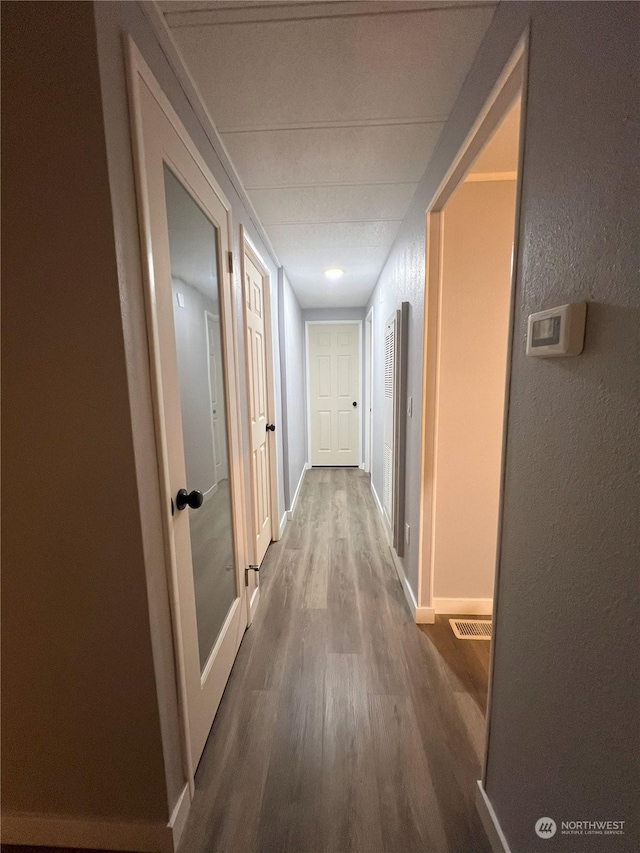 corridor with hardwood / wood-style flooring