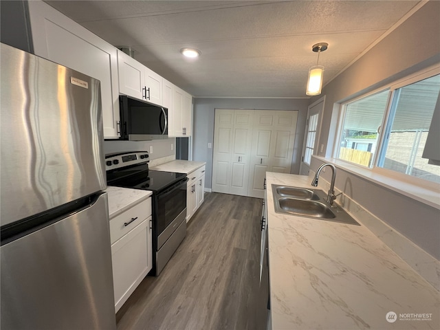 kitchen featuring sink, decorative light fixtures, stainless steel appliances, and light stone countertops