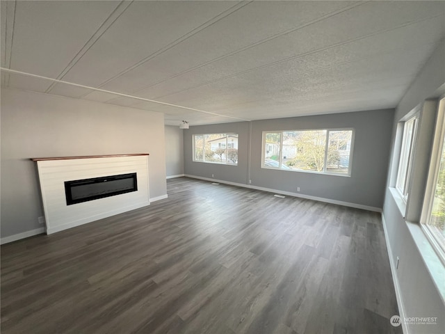 unfurnished living room with plenty of natural light and dark hardwood / wood-style floors