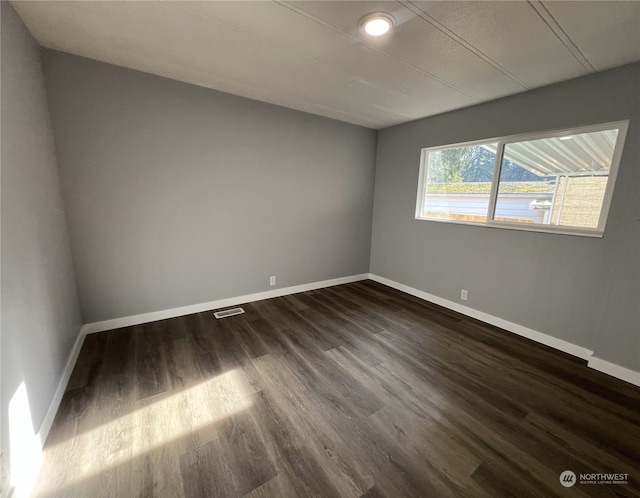 unfurnished room with dark hardwood / wood-style flooring