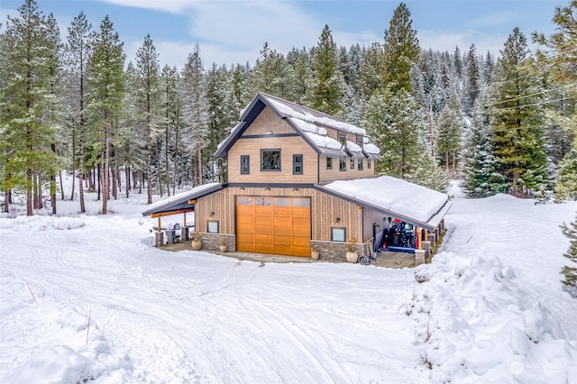 snow covered property featuring a garage