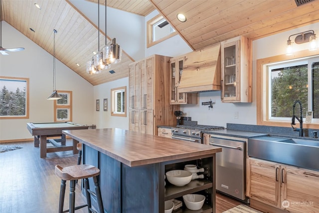 kitchen featuring a center island, a kitchen breakfast bar, sink, decorative light fixtures, and stainless steel appliances