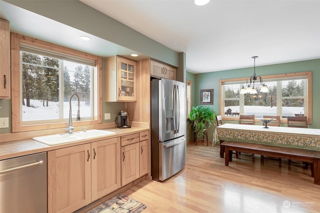 kitchen with pendant lighting, an inviting chandelier, sink, light brown cabinetry, and appliances with stainless steel finishes