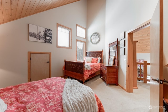 carpeted bedroom with high vaulted ceiling and wood ceiling