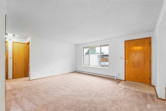 carpeted spare room featuring baseboard heating and a textured ceiling