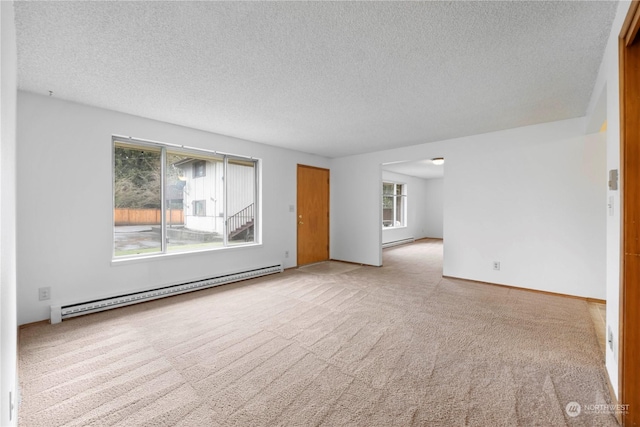 carpeted spare room with a baseboard radiator and a textured ceiling