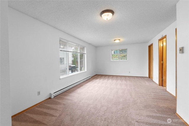 unfurnished room with baseboard heating, carpet, and a textured ceiling