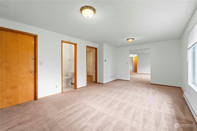 carpeted empty room featuring baseboard heating and a textured ceiling