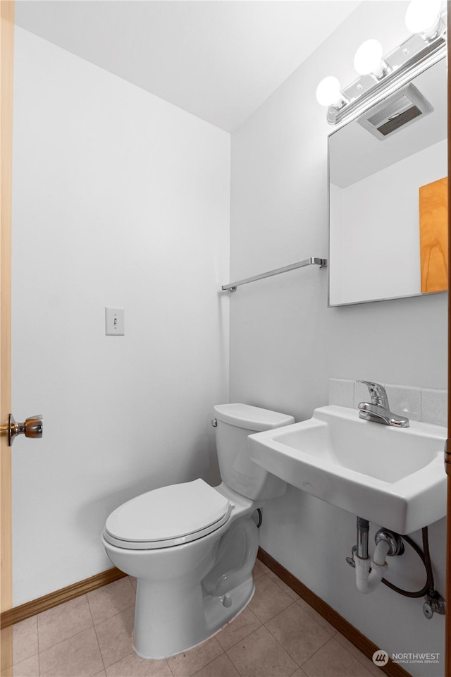 bathroom with tile patterned flooring, toilet, and baseboards