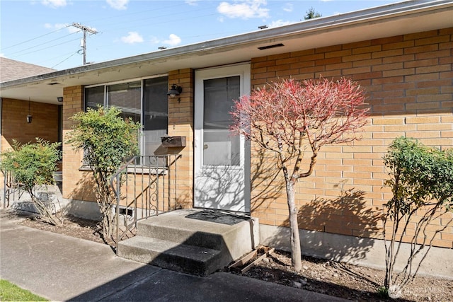 doorway to property featuring brick siding