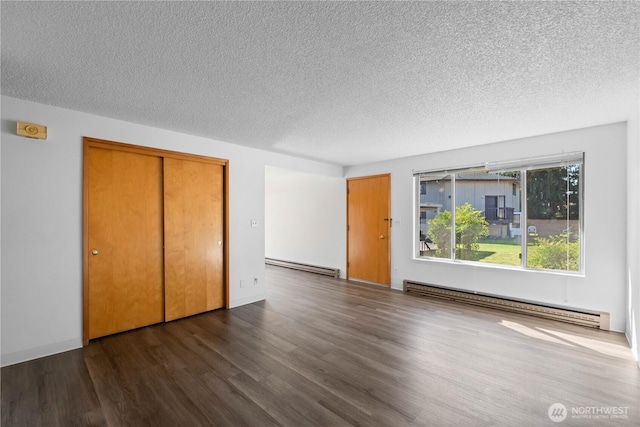 unfurnished bedroom featuring a closet, a textured ceiling, wood finished floors, and a baseboard radiator