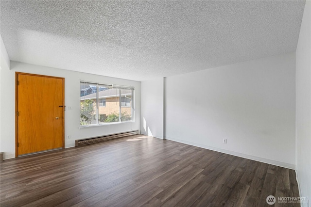 empty room featuring a textured ceiling, a baseboard heating unit, and wood finished floors