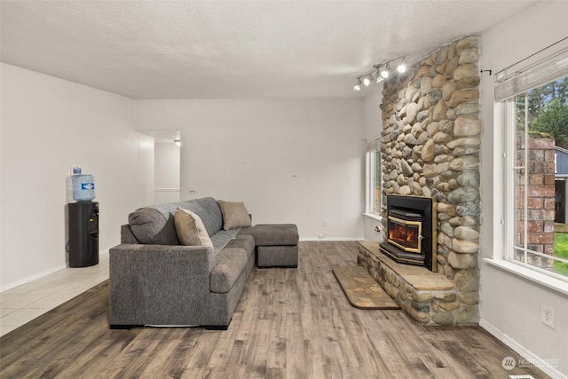 living room featuring a textured ceiling, hardwood / wood-style flooring, and a wood stove