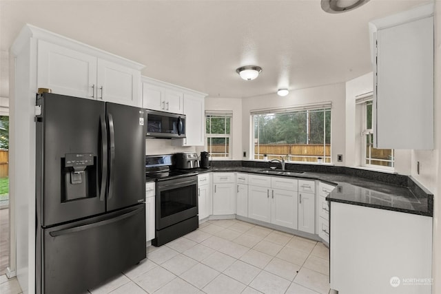 kitchen with white cabinetry, sink, light tile patterned floors, and stainless steel appliances