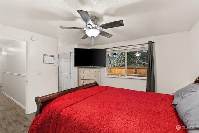 bedroom with hardwood / wood-style flooring, ceiling fan, and a textured ceiling