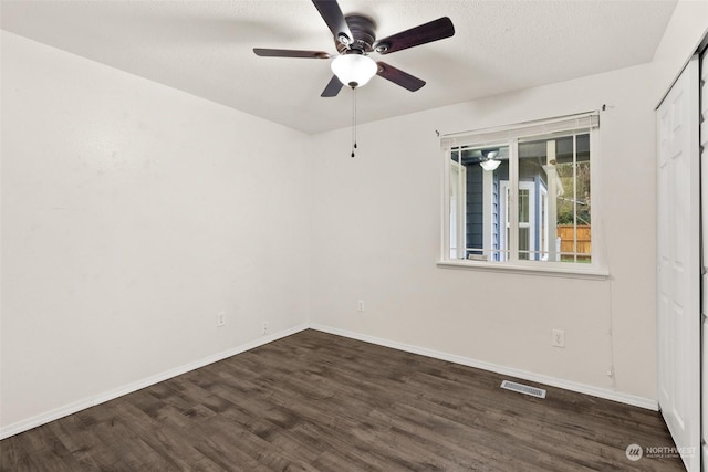 empty room featuring ceiling fan and dark hardwood / wood-style flooring