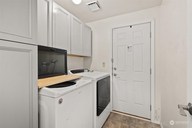 washroom with cabinets and washing machine and dryer