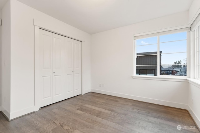 unfurnished bedroom with light hardwood / wood-style floors and a closet