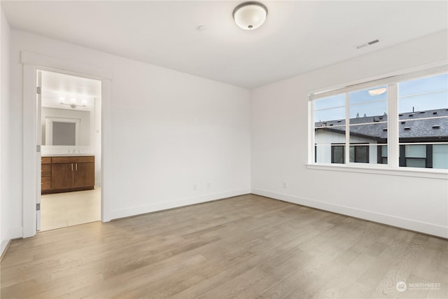 spare room with light hardwood / wood-style flooring and sink