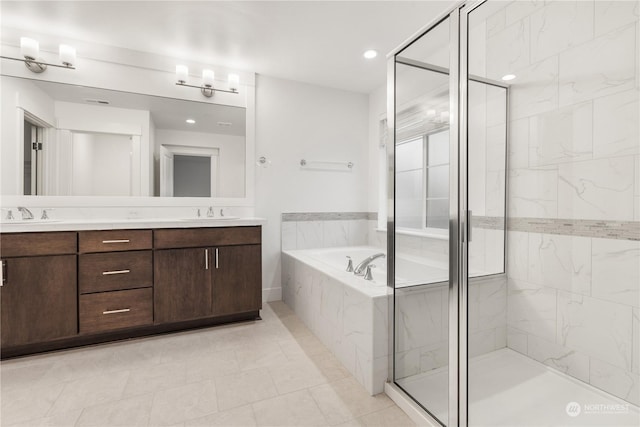 bathroom with tile patterned floors, vanity, and shower with separate bathtub