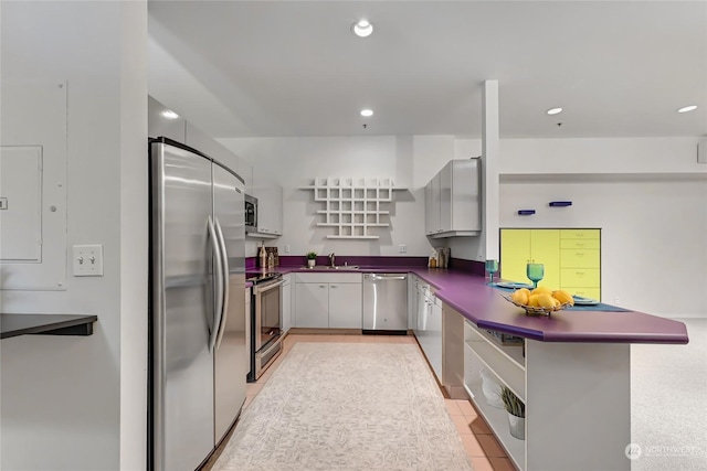 kitchen featuring stainless steel appliances, sink, light tile patterned floors, and kitchen peninsula