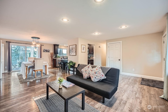 living room with light hardwood / wood-style floors and an inviting chandelier