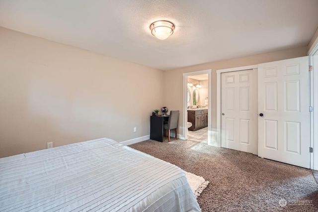 carpeted bedroom featuring ensuite bathroom, a closet, and a textured ceiling