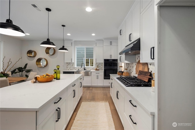 kitchen featuring a kitchen island, pendant lighting, decorative backsplash, and white cabinetry