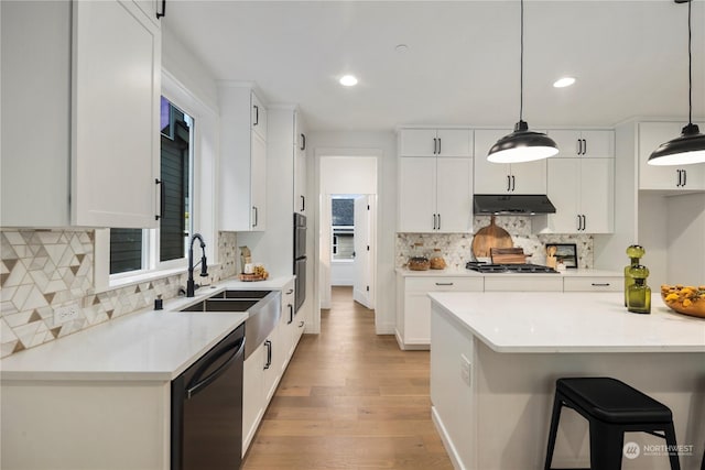 kitchen with pendant lighting, white cabinets, and dishwasher