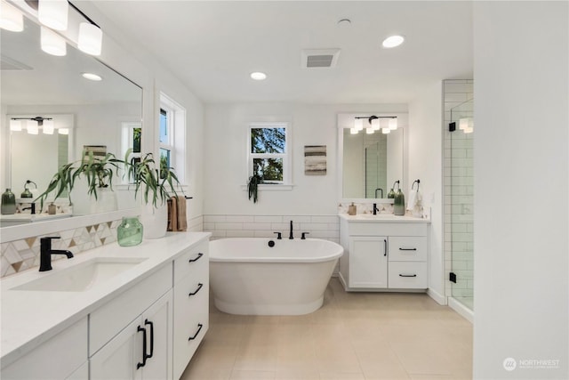 bathroom with tile patterned flooring, tile walls, separate shower and tub, and vanity