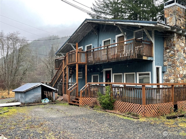 view of front of property with an outdoor structure and a wooden deck