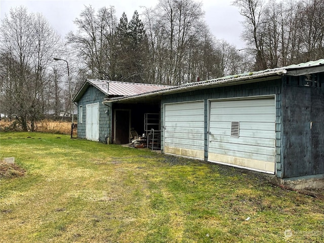 view of outbuilding with a lawn and a garage