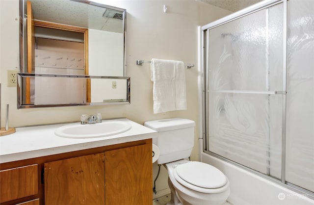 full bathroom featuring toilet, vanity, and bath / shower combo with glass door