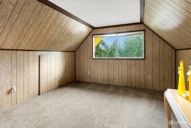 bonus room featuring lofted ceiling, wood walls, and carpet