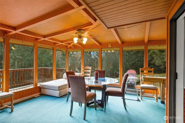 sunroom featuring beamed ceiling and ceiling fan