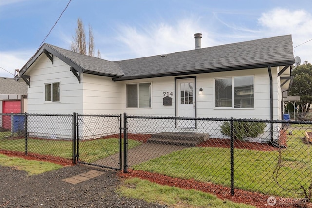 view of front facade featuring a shingled roof, a front yard, a gate, and fence