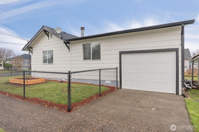 view of home's exterior featuring a garage, a lawn, driveway, and fence