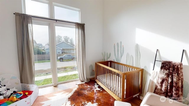 bedroom featuring a crib and multiple windows