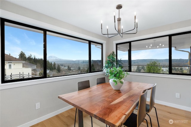 dining room featuring a mountain view, a chandelier, and light wood-type flooring