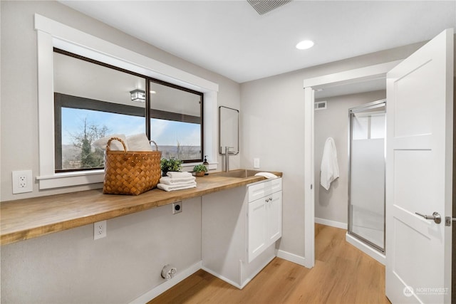 bathroom featuring a shower, vanity, and hardwood / wood-style flooring