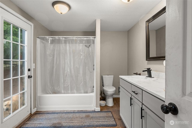 full bathroom with vanity, shower / bath combination with curtain, a textured ceiling, and toilet