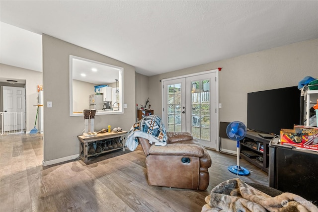 living room featuring french doors, lofted ceiling, and hardwood / wood-style floors