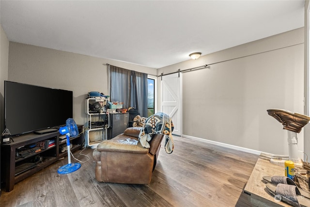 living area featuring a barn door and hardwood / wood-style flooring