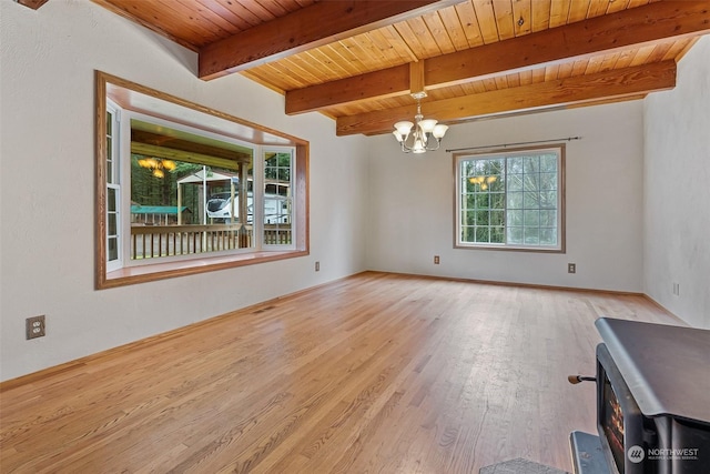 spare room featuring beam ceiling, wooden ceiling, light hardwood / wood-style flooring, and a chandelier