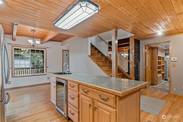 kitchen featuring wine cooler, sink, beam ceiling, wooden ceiling, and a kitchen island