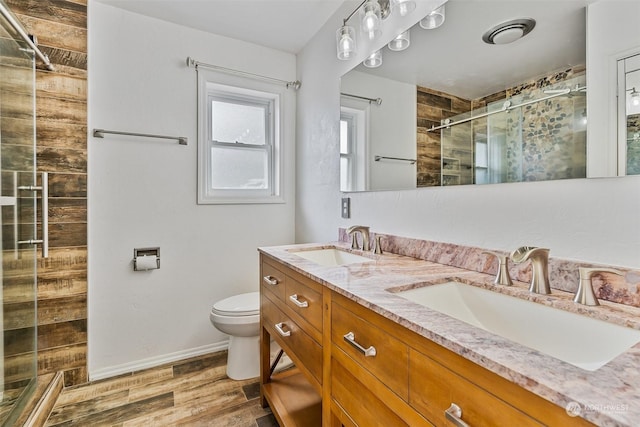 bathroom with hardwood / wood-style floors, vanity, toilet, and an enclosed shower