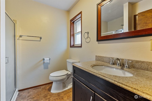 bathroom with vanity, toilet, and a shower with door